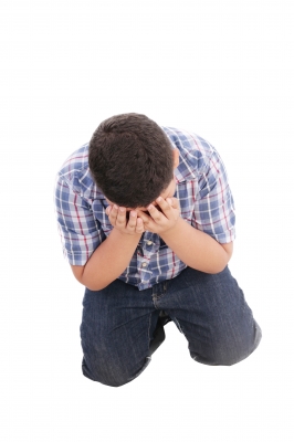 teen boy on knees with head in hands feeling stuck