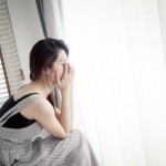 Teen who is feeling antisocial. Girl holding head in hands.