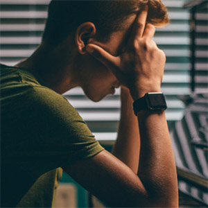 Teen Boy With Head in Hands Because He Is Dealing With A Depressive Episode As Part of Bipolar Disorder