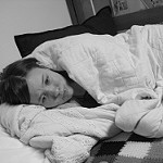 black and white image of woman lying in bed dealing with depression